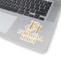 Grey laptop with black keyboard featuring a gold Formula Haus monogram sticker on the palm rest